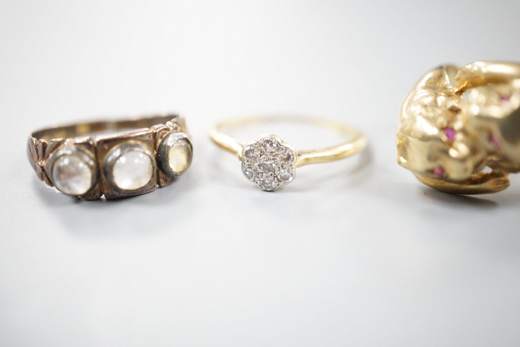 A modern 9ct gold and gem set twin leopards head ring, size S, gross 5.6 grams, a late Victorian 15ct gold and three stone moonstone ring, size M/N (shank cut), gross 3.3 grams and an 18ct and diamond cluster ring, size
